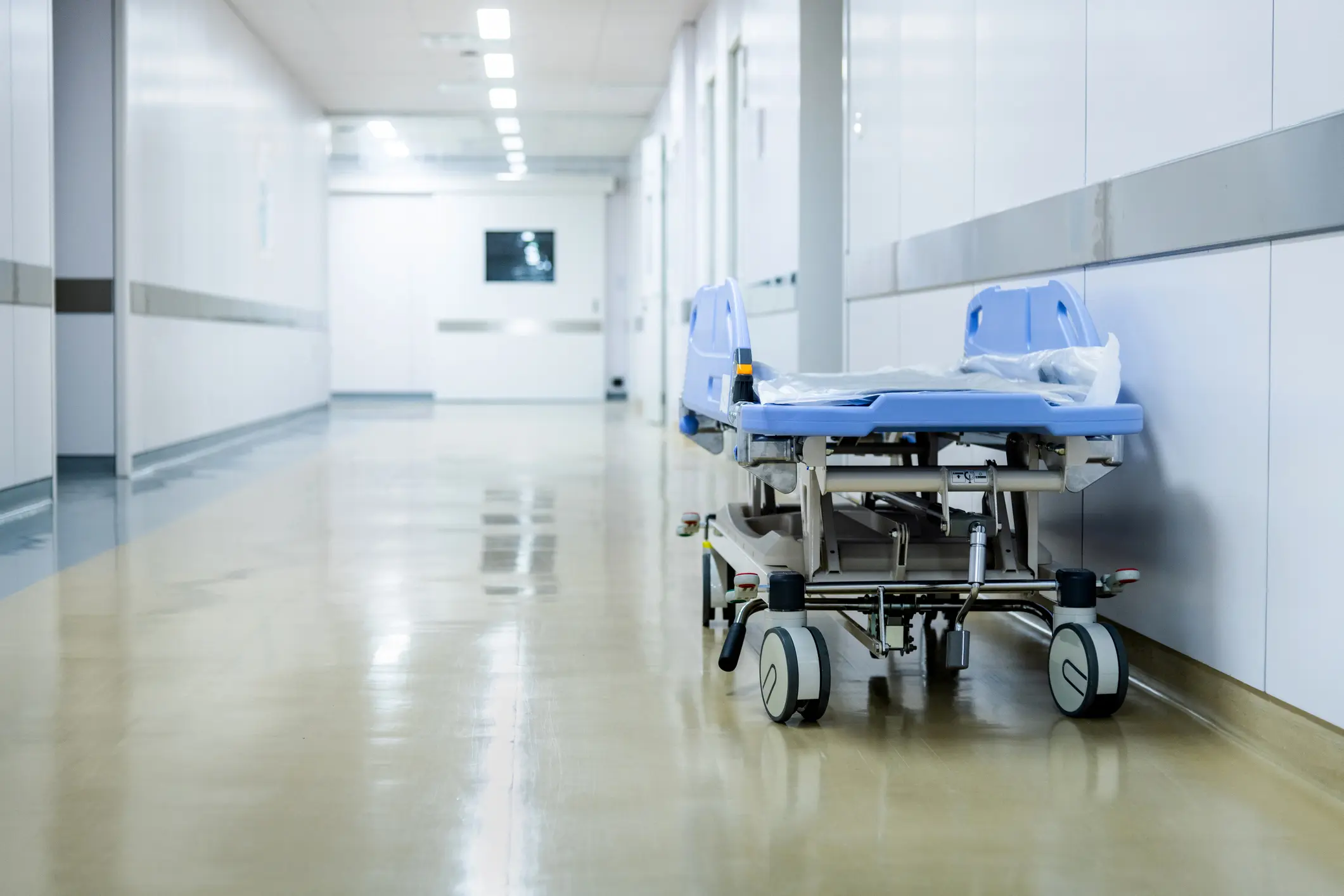 Empty bed in hospital hallway